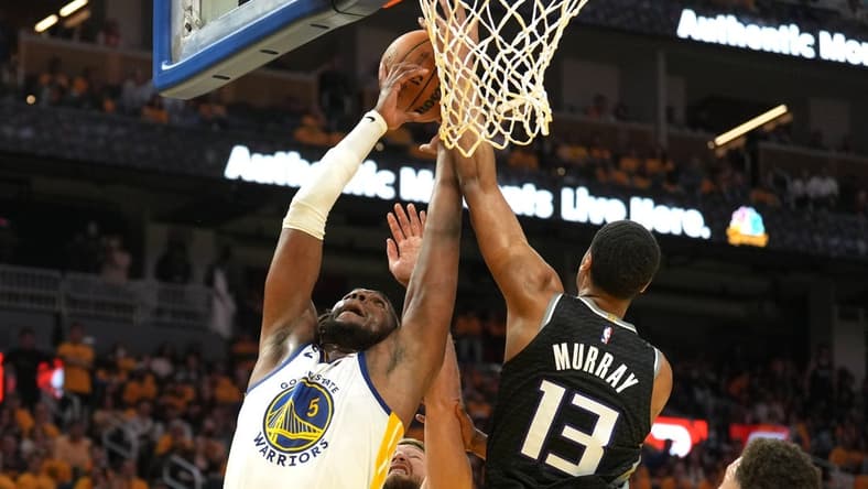 Apr 23, 2023; San Francisco, California, USA; Golden State Warriors forward Kevon Looney (5) reaches for a rebound against Sacramento Kings forward Keegan Murray (13) and forward Domantas Sabonis (lower center) during the third quarter of game four of the 2023 NBA playoffs at Chase Center. Mandatory Credit: Darren Yamashita-USA TODAY Sports