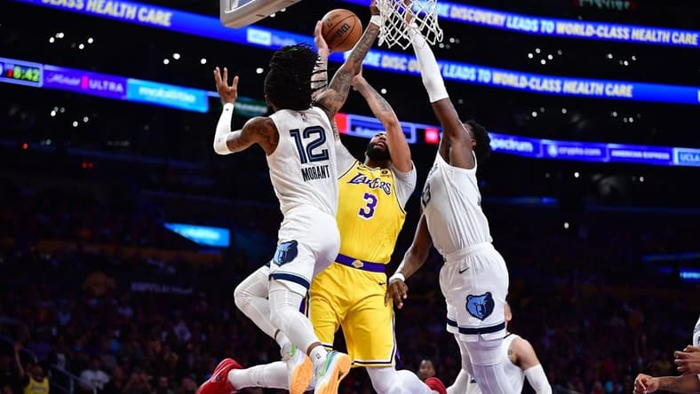 Apr 24, 2023; Los Angeles, California, USA; Los Angeles Lakers forward Anthony Davis (3) moves to the basket against Memphis Grizzlies guard Ja Morant (12) and forward Jaren Jackson Jr. (13) during the first half in game four of the 2023 NBA playoffs at Crypto.com Arena. Mandatory Credit: Gary A. Vasquez-USA TODAY Sports