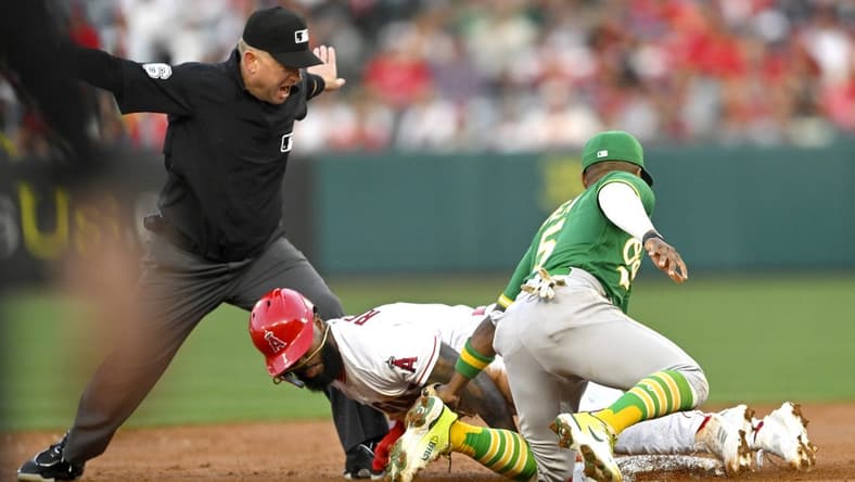 Apr 25, 2023; Anaheim, California, USA;  Second base umpire Mike Muchlinski calls Los Angeles Angels second baseman Luis Rengifo (2) safe on a stole base as he beats the tag by Oakland Athletics second baseman Tony Kemp (5) in the first inning at Angel Stadium. Mandatory Credit: Jayne Kamin-Oncea-USA TODAY Sports