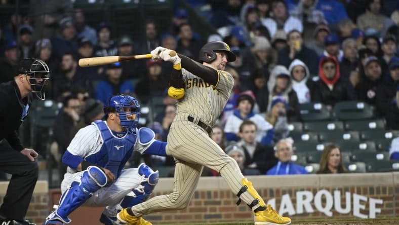 Apr 26, 2023; Chicago, Illinois, USA;  San Diego Padres first baseman Jake Cronenworth (9) hits an RBI triple against the Chicago Cubs during the fourth inning at Wrigley Field. Mandatory Credit: Matt Marton-USA TODAY Sports