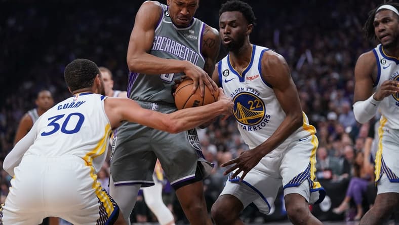 Apr 26, 2023; Sacramento, California, USA; Sacramento Kings guard Malik Monk (0) holds onto the ball next to Golden State Warriors guard Stephen Curry (30) and forward Andrew Wiggins (22) in the second quarter during game five of the 2023 NBA playoffs at the Golden 1 Center. Mandatory Credit: Cary Edmondson-USA TODAY Sports