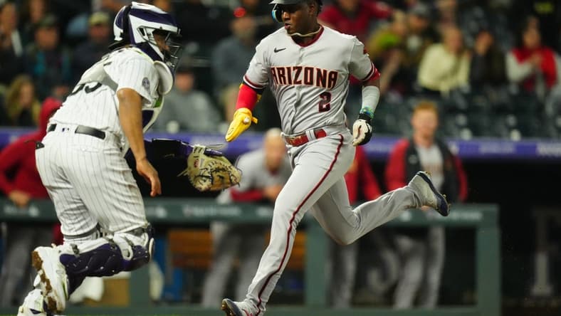 Apr 28, 2023; Denver, Colorado, USA; Arizona Diamondbacks shortstop Geraldo Perdomo (2) scores a run in front of Colorado Rockies catcher Elias Diaz (35) in the seventh inning at Coors Field. Mandatory Credit: Ron Chenoy-USA TODAY Sports