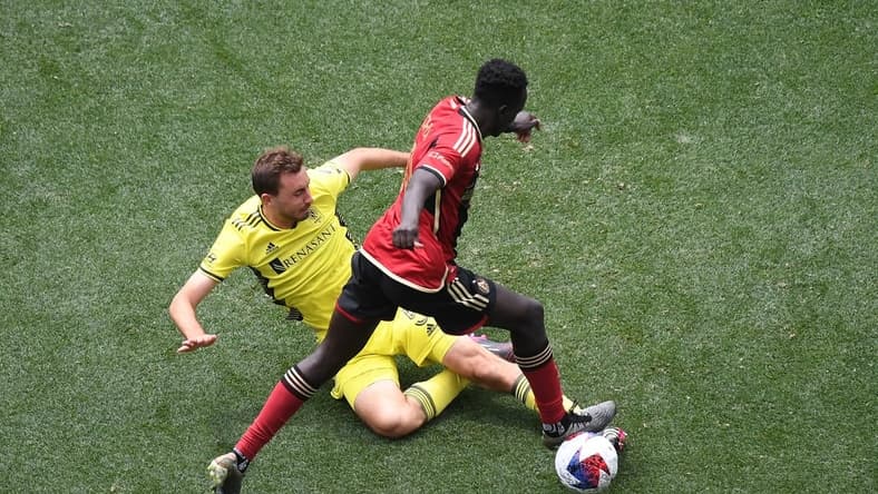 Apr 29, 2023; Nashville, TN, USA; Nashville SC defender Jack Maher (5) battles for the ball against Atlanta United forward Machop Chol (30) in the second half of a MLS game at Geodis Park. Mandatory Credit: Christopher Hanewinckel-USA TODAY Sports