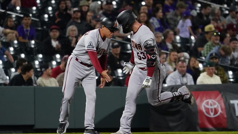 Apr 29, 2023; Denver, Colorado, USA;  Arizona Diamondbacks first baseman Christian Walker (53) hits a solo home run in the top of the ninth inning at Coors Field. Walker gets a low five from Arizona Diamondbacks third base coach Tony Perezchica (21). Mandatory Credit: Michael Madrid-USA TODAY Sports