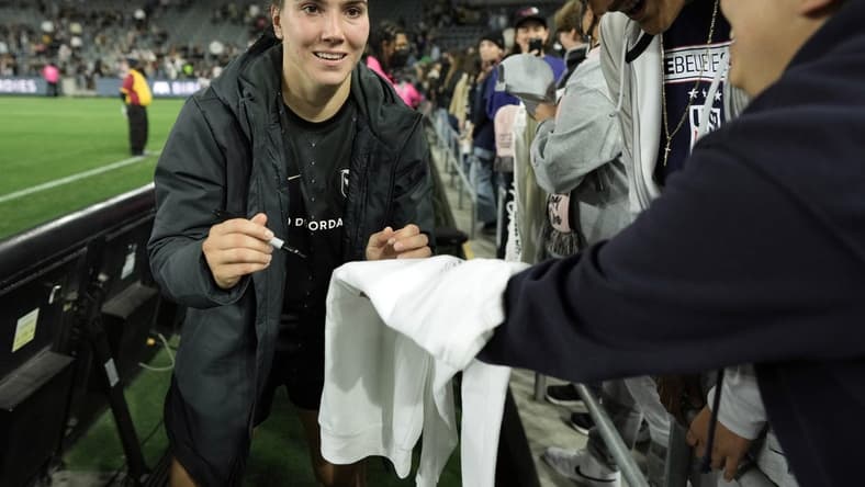 May 21, 2022; Los Angeles, California, USA; Angel City FC defender Vanessa Giles (4) signs autographs after the win against the Kansas City Current at Banc of California Stadium. Mandatory Credit: Kirby Lee-USA TODAY Sports