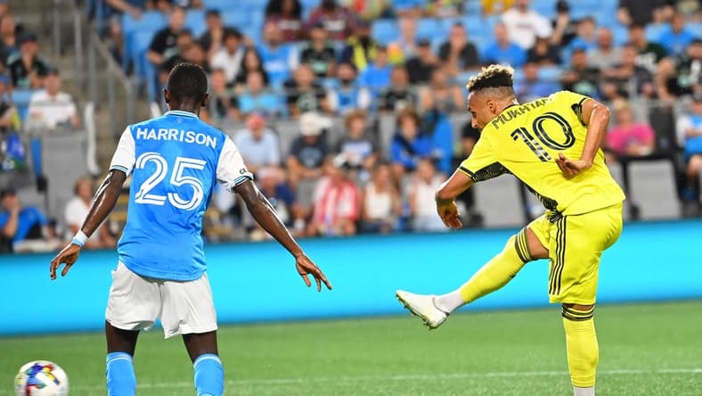 Jul 9, 2022; Charlotte, North Carolina, USA; Nashville SC midfielder Hany Mukhtar (10) with his arm behind his back after he shoots as Charlotte FC defender Harrison Afful (25) defends in the second half at Bank of America Stadium. Mandatory Credit: Bob Donnan-USA TODAY Sports