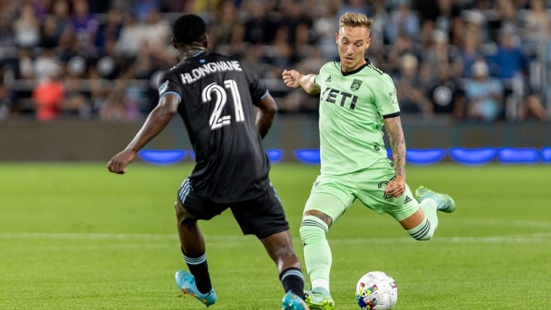Aug 20, 2022; Saint Paul, Minnesota, USA; Austin FC defender Zan Kolmanic (23) passes in front of Minnesota United forward Bongokuhle Hlongwane (21) meet at Allianz Field. Mandatory Credit: Matt Blewett-USA TODAY Sports