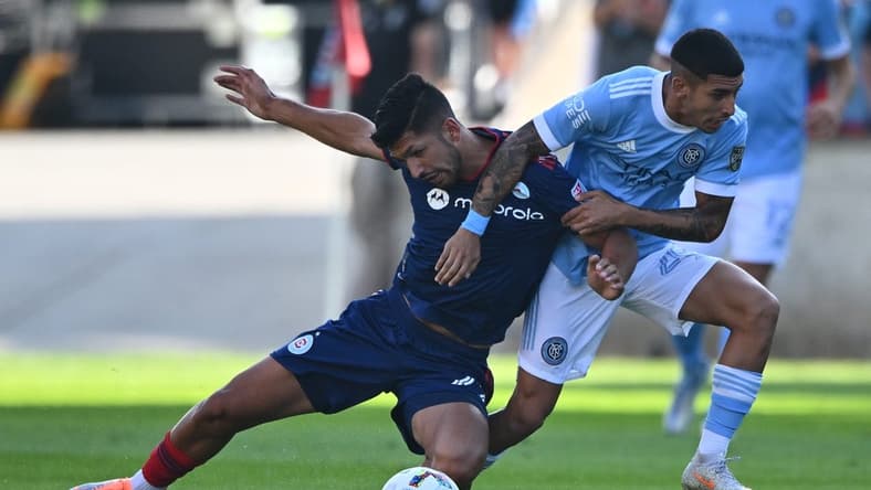 Aug 21, 2022; Chicago, Illinois, USA;  Chicago Fire FC defender Mauricio Pineda (22) is pulled down by New York City FC midfielder Santiago Rodriguez (20) in the first half at Bridgeview Stadium. Mandatory Credit: Jamie Sabau-USA TODAY Sports