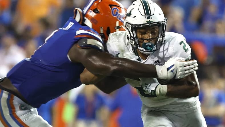 Sep 17, 2022; Gainesville, Florida, USA; South Florida Bulls running back Michel Dukes (2) runs with the ball as Florida Gators linebacker Brenton Cox Jr. (1) defends during the second half at Ben Hill Griffin Stadium. Mandatory Credit: Kim Klement-USA TODAY Sports