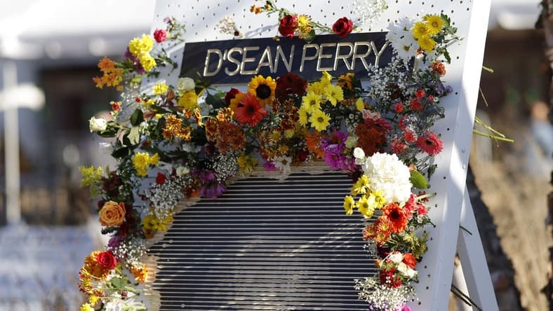 Nov 19, 2022; Charlottesville, Virginia, US; A partial view of a flower board with an image of D'Sean Perry, one of three Virginia Cavaliers football players killed in a campus shooting on November 13th is displayed prior to the start of a memorial at John Paul Jones Arena. Mandatory Credit: Geoff Burke-USA TODAY Sports