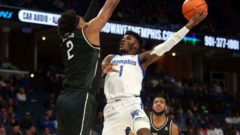 Feb 16, 2023; Memphis, Tennessee, USA; Memphis Tigers guard Keonte Kennedy (1) shoots as UCF Knights forward Michael Durr (2) defends during the first half at FedExForum. Mandatory Credit: Petre Thomas-USA TODAY Sports