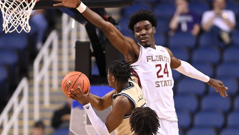 Mar 7, 2023; Greensboro, NC, USA; Georgia Tech Yellow Jackets guard Miles Kelly (13) looks to shoot as Florida State Seminoles center Naheem McLeod (24) defends in the second half of the first round of the ACC Tournament at Greensboro Coliseum. Mandatory Credit: Bob Donnan-USA TODAY Sports