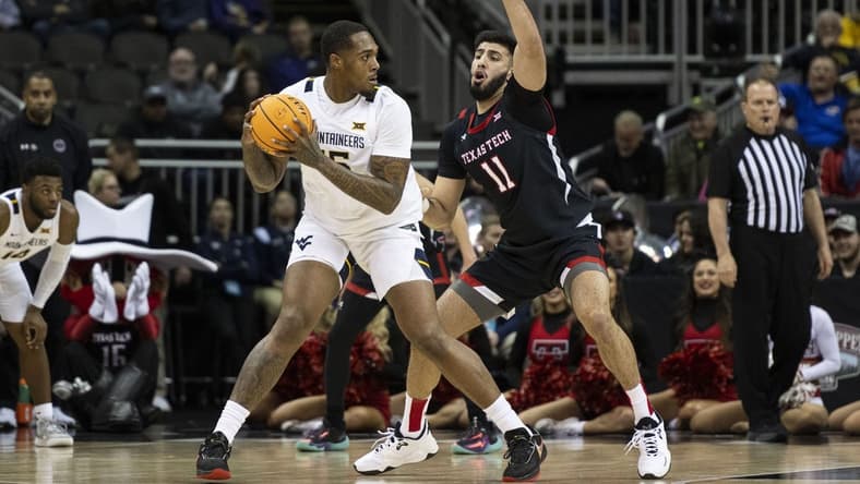 Mar 8, 2023; Kansas City, MO, USA; West Virginia Mountaineers forward Jimmy Bell Jr. (15) handles the ball while defended by Texas Tech Red Raiders forward Fardaws Aimaq (11) in the first half at T-Mobile Center. Mandatory Credit: Amy Kontras-USA TODAY Sports