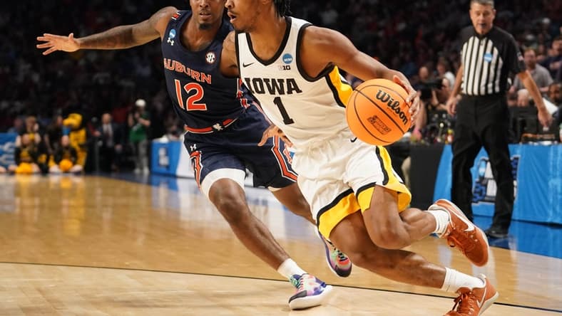 Mar 16, 2023; Birmingham, AL, USA;  Iowa Hawkeyes guard Ahron Ulis (1) drives around Auburn Tigers guard Zep Jasper (12) during the first half in the first round of the 2023 NCAA Tournament at Legacy Arena. Mandatory Credit: Marvin Gentry-USA TODAY Sports