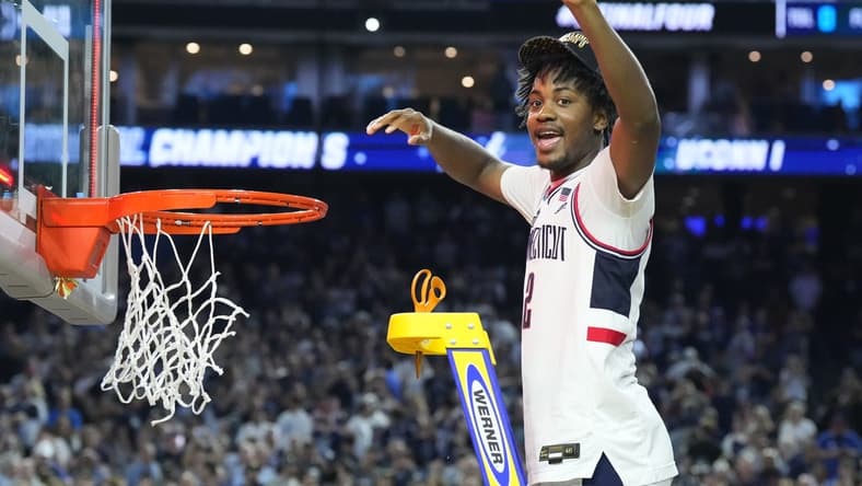Apr 3, 2023; Houston, TX, USA; Connecticut Huskies guard Tristen Newton (2) cuts down a piece of the net after defeating the San Diego State Aztecs in the national championship game of the 2023 NCAA Tournament at NRG Stadium. Mandatory Credit: Robert Deutsch-USA TODAY Sports