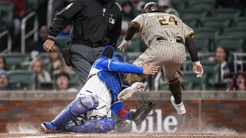 Apr 8, 2023; Cumberland, Georgia, USA; San Diego Padres right fielder Rougned Odor (24) is tagged out on a collision with Atlanta Braves catcher Travis d'Arnaud (16) during the fourth inning at Truist Park. Mandatory Credit: Dale Zanine-USA TODAY Sports