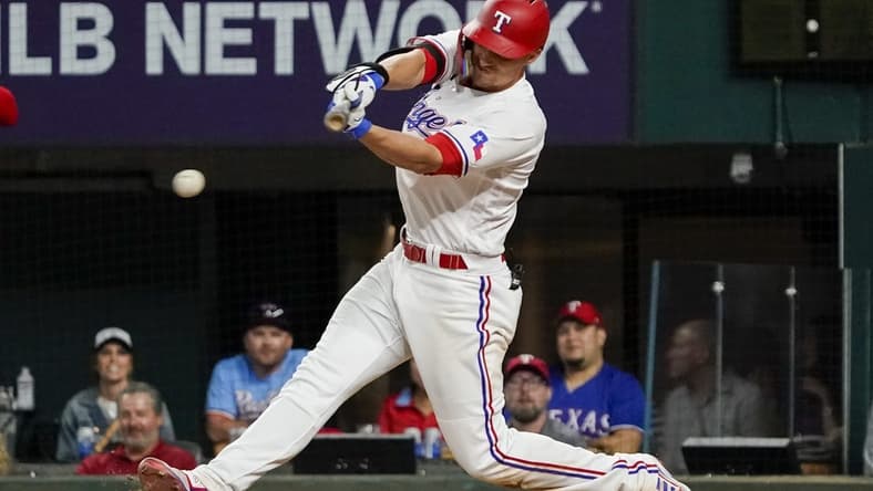 Apr 10, 2023; Arlington, Texas, USA; Texas Rangers shortstop Corey Seager (5) hits a single during the eighth inning against the Kansas City Royals at Globe Life Field. Mandatory Credit: Raymond Carlin III-USA TODAY Sports