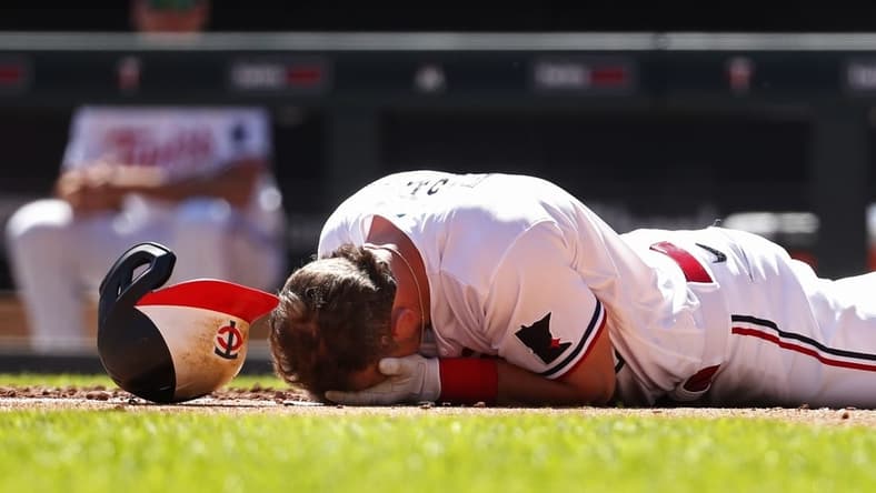 Apr 12, 2023; Minneapolis, Minnesota, USA; Minnesota Twins second baseman Kyle Farmer (12) drops to the ground after getting hit by a pitch in the face by the Chicago White Sox in the fourth inning at Target Field. Mandatory Credit: Bruce Kluckhohn-USA TODAY Sports