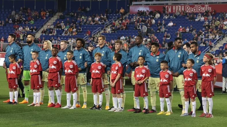 Apr 15, 2023; Harrison, New Jersey, USA; New York Red Bulls players stand with young fans during the national anthem before the game against the Houston Dynamo at Red Bull Arena. Mandatory Credit: Vincent Carchietta-USA TODAY Sports