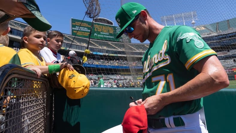 Apr 30, 2023; Oakland, California, USA; Oakland Athletics bullpen coach Mike McCarthy (71) signs autographs for fans before the start of the first inning against the Cincinnati Reds at RingCentral Coliseum. Mandatory Credit: Stan Szeto-USA TODAY Sports