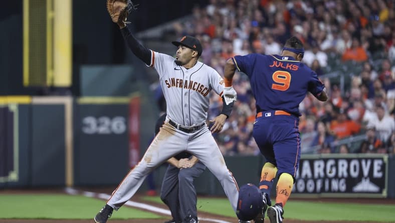 May 1, 2023; Houston, Texas, USA; Houston Astros left fielder Corey Julks (9) is out at first base as San Francisco Giants first baseman LaMonte Wade Jr. (31) fields a throw during the second inning at Minute Maid Park. Mandatory Credit: Troy Taormina-USA TODAY Sports