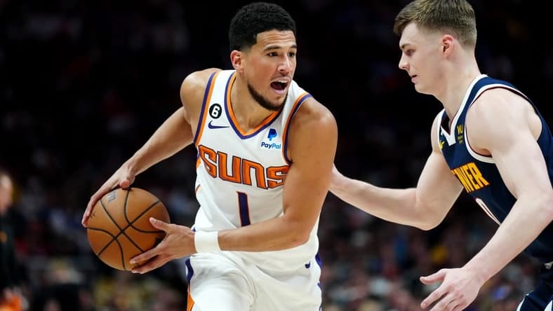 May 1, 2023; Denver, Colorado, USA; Phoenix Suns guard Devin Booker (1) and Denver Nuggets guard Christian Braun (0)  in the first half during game two of the 2023 NBA playoffs at Ball Arena. Mandatory Credit: Ron Chenoy-USA TODAY Sports