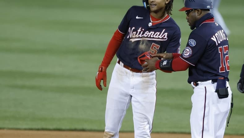 May 2, 2023; Washington, District of Columbia, USA; Washington Nationals shortstop CJ Abrams (5) celebrates with Nationals first base coach Eric Young Jr. (12) after hitting and RBI single against the Chicago Cubs during the seventh inning at Nationals Park. Mandatory Credit: Geoff Burke-USA TODAY Sports