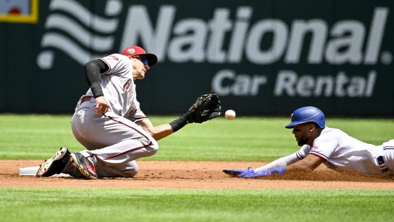 May 3, 2023; Arlington, Texas, USA; Arizona Diamondbacks shortstop Nick Ahmed (13) tags out Texas Rangers center fielder Leody Taveras (3) on a steal attempt during the second inning at Globe Life Field. Mandatory Credit: Jerome Miron-USA TODAY Sports