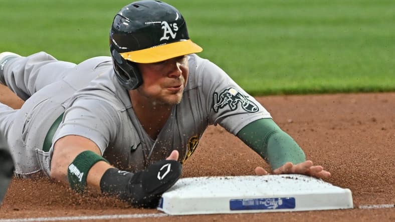May 5, 2023; Kansas City, Missouri, USA; Oakland Athletics designated hitter Brent Rooker (25) dives into third base after a wild pitch during the first inning against the Kansas City Royals at Kauffman Stadium. Mandatory Credit: Peter Aiken-USA TODAY Sports