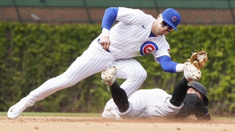 May 6, 2023; Chicago, Illinois, USA; Chicago Cubs second baseman Nico Hoerner (2) tags out Miami Marlins shortstop Jon Berti (5) at second base on a steal attempt of second base during the fifth inning at Wrigley Field. Mandatory Credit: David Banks-USA TODAY Sports
