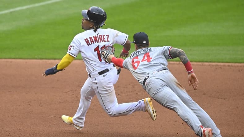 May 6, 2023; Cleveland, Ohio, USA; Cleveland Guardians third baseman Jose Ramirez (11) eludes a tag attempt by Minnesota Twins third baseman Jose Miranda (64) in the fourth inning at Progressive Field. Mandatory Credit: David Richard-USA TODAY Sports