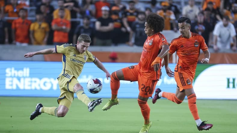 May 6, 2023; Houston, Texas, USA; Real Salt Lake midfielder Scott Caldwell (12) and Houston Dynamo FC midfielder Adalberto Carrasquilla (20) battle for the ball during the first half at Shell Energy Stadium. Mandatory Credit: Troy Taormina-USA TODAY Sports