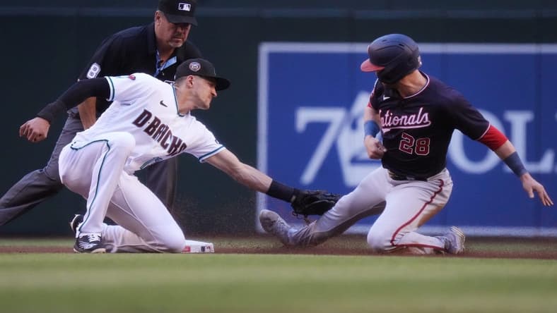 May 6, 2023; Phoenix, AZ, USA; Arizona Diamondbacks short stop Nick Ahmed (13) tags out Washington Nationals' Lane Thomas (28) on a steal attempt at Chase Field.