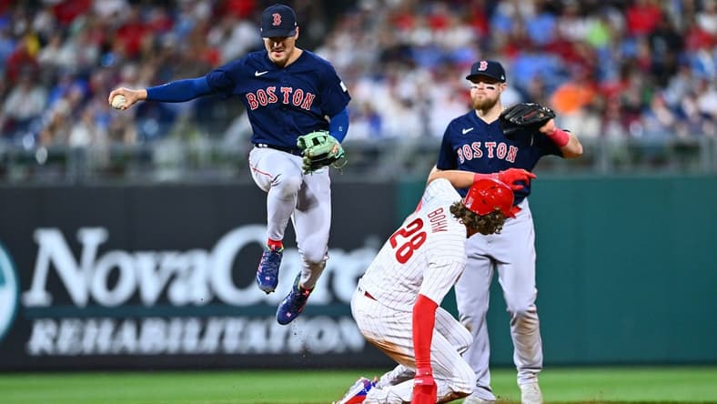 May 6, 2023; Philadelphia, Pennsylvania, USA; Boston Red Sox shortstop Kike Hernandez (5) leaps over Philadelphia Phillies infielder Alec Bohm (28) in the sixth inning at Citizens Bank Park. Mandatory Credit: Kyle Ross-USA TODAY Sports