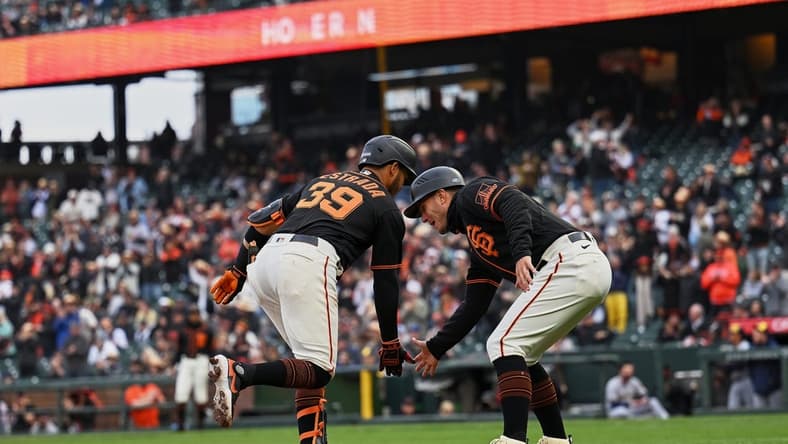May 6, 2023; San Francisco, California, USA; San Francisco Giants infielder Thairo Estrada (39) shakes hands with third base coach Mark Hallberg (91) after hitting a two-run home run against the Milwaukee Brewers during the third inning at Oracle Park. Mandatory Credit: Robert Edwards-USA TODAY Sports
