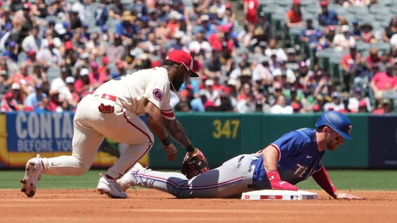 May 7, 2023; Anaheim, California, USA; Texas Rangers right fielder Robbie Grossman (4) slides beneath the tag of Los Angeles Angels second baseman Luis Rengifo (2) into second base in the first inning at Angel Stadium. Mandatory Credit: Kirby Lee-USA TODAY Sports