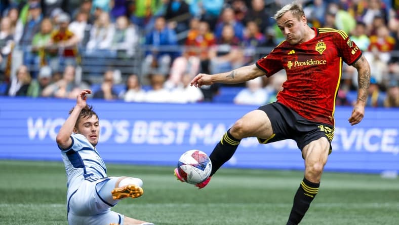 May 7, 2023; Seattle, Washington, USA; Seattle Sounders FC forward Jordan Morris (13, right) attempts a shot against Sporting Kansas City midfielder Jake Davis (17) during the second half at Lumen Field. Mandatory Credit: Joe Nicholson-USA TODAY Sports