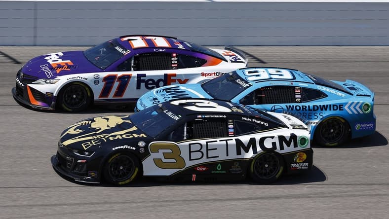 May 7, 2023; Kansas City, Kansas, USA; NASCAR Cup Series driver Denny Hamlin (11), driver Austin Dillon (3) and  driver Daniel Suarez (99) race three wide during the AdventHealth 400 at Kansas Speedway. Mandatory Credit: Mike Dinovo-USA TODAY Sports