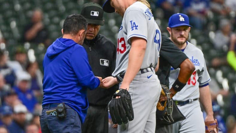 May 9, 2023; Milwaukee, Wisconsin, USA; Los Angeles Dodgers pitcher Noah Syndergaard (43) is checked by a trainer in the first inning during game against the Milwaukee Brewers at American Family Field. Syndergaard later left the game with a possible hand injury. Mandatory Credit: Benny Sieu-USA TODAY Sports