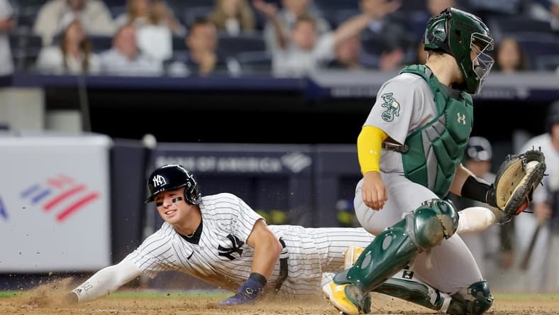 May 9, 2023; Bronx, New York, USA; New York Yankees shortstop Anthony Volpe (11) scores against Oakland Athletics catcher Shea Langeliers (23) on a sacrifice fly by Yankees right fielder Aaron Judge (not pictured) during the eighth inning at Yankee Stadium. Mandatory Credit: Brad Penner-USA TODAY Sports