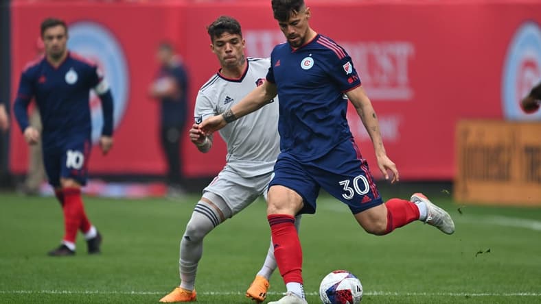 May 13, 2023; Chicago, Illinois, USA; Chicago Fire FC midfielder Gaston Gimenez (30) controls the ball as St. Louis City SC midfielder Celio Pompeu (12) defends in the first half at Soldier Field. Mandatory Credit: Jamie Sabau-USA TODAY Sports