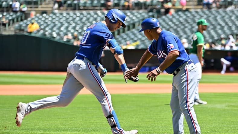 May 13, 2023; Oakland, California, USA; Texas Rangers infielder Nathaniel Lowe (30) celebrates with third base coach Tony Beasley (27) after hitting a home run during the fourth inning against the Oakland Athletics at Oakland-Alameda County Coliseum. Mandatory Credit: Robert Edwards-USA TODAY Sports