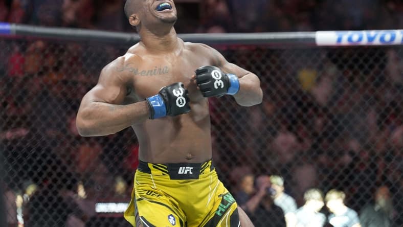 May 13, 2023; Charlotte, North Carolina, USA; Jailton Almeida (blue gloves) reacts after defeating Jairzinho Rozenstruik (red gloves) in a heavyweight bout during UFC Fight Night at Spectrum Center. Mandatory Credit: Jim Dedmon-USA TODAY Sports