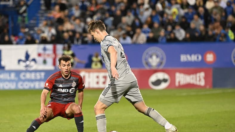 May 13, 2023; Montreal, Quebec, CAN; CF Montreal midfielder Lassi Lappalainen (21) controls the ball defended by Toronto FC midfielder Kobe Franklin (19) in the second half at Stade Saputo. Mandatory Credit: David Kirouac-USA TODAY Sports