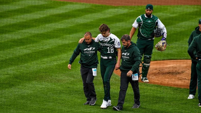 May 13, 2023; Denver, Colorado, USA; Colorado Rockies starting pitcher Ryan Feltner (18) is helped off the field by the medical staff after getting hit by a line drive by Philadelphia Phillies Nick Castellanos in the second inning at Coors Field. Mandatory Credit: John Leyba-USA TODAY Sports