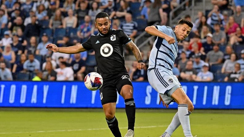 May 13, 2023; Kansas City, Kansas, USA; Minnesota United defender D.J. Taylor (27) battles for the ball against Sporting Kansas City forward Daniel Salloi (20) at Children's Mercy Park. Mandatory Credit: Peter Aiken-USA TODAY Sports
