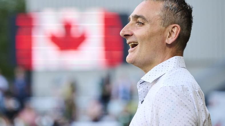 May 13, 2023; Portland, Oregon, USA; Vancouver Whitecaps head coach Vanni Sartini sings along during the a performance of the Canadian National Anthem before a game against the Portland Timbers at Providence Park. Mandatory Credit: Troy Wayrynen-USA TODAY Sports