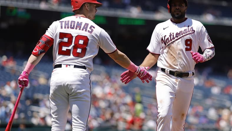 May 14, 2023; Washington, District of Columbia, USA;Washington Nationals third baseman Jeimer Candelario (9) celebrates with Nationals right fielder Lane Thomas (28) after scoring a run on an RBI single by Nationals shortstop CJ Abrams (not pictured) against the New York Mets during the fourth inning of the continuation of a suspended game at Nationals Park. Mandatory Credit: Geoff Burke-USA TODAY Sports