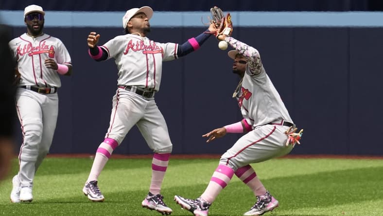 May 14, 2023; Toronto, Ontario, CAN; Atlanta Braves second baseman Ozzie Albies (center) and right fielder Ronald Acuna Jr. (right) drop the ball as they collide while attempting to catch a ball hit by Toronto Blue Jays left fielder Whit Merrifield (not pictured) during the second inning at Rogers Centre. Mandatory Credit: John E. Sokolowski-USA TODAY Sports
