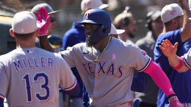 May 14, 2023; Oakland, California, USA; Texas Rangers right fielder Adolis Garcia (center) celebrates with teammates after hitting a grand slam home run against the Oakland Athletics during the eighth inning at Oakland-Alameda County Coliseum. Mandatory Credit: Darren Yamashita-USA TODAY Sports